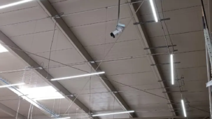 Cámara de videovigilancia instalada en el interior de una tienda con techo de gran altura