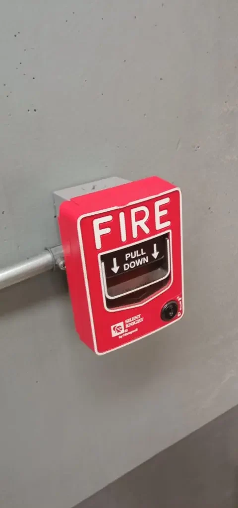 Estación manual de alarma contra incendio instalada sobre canalización metálica